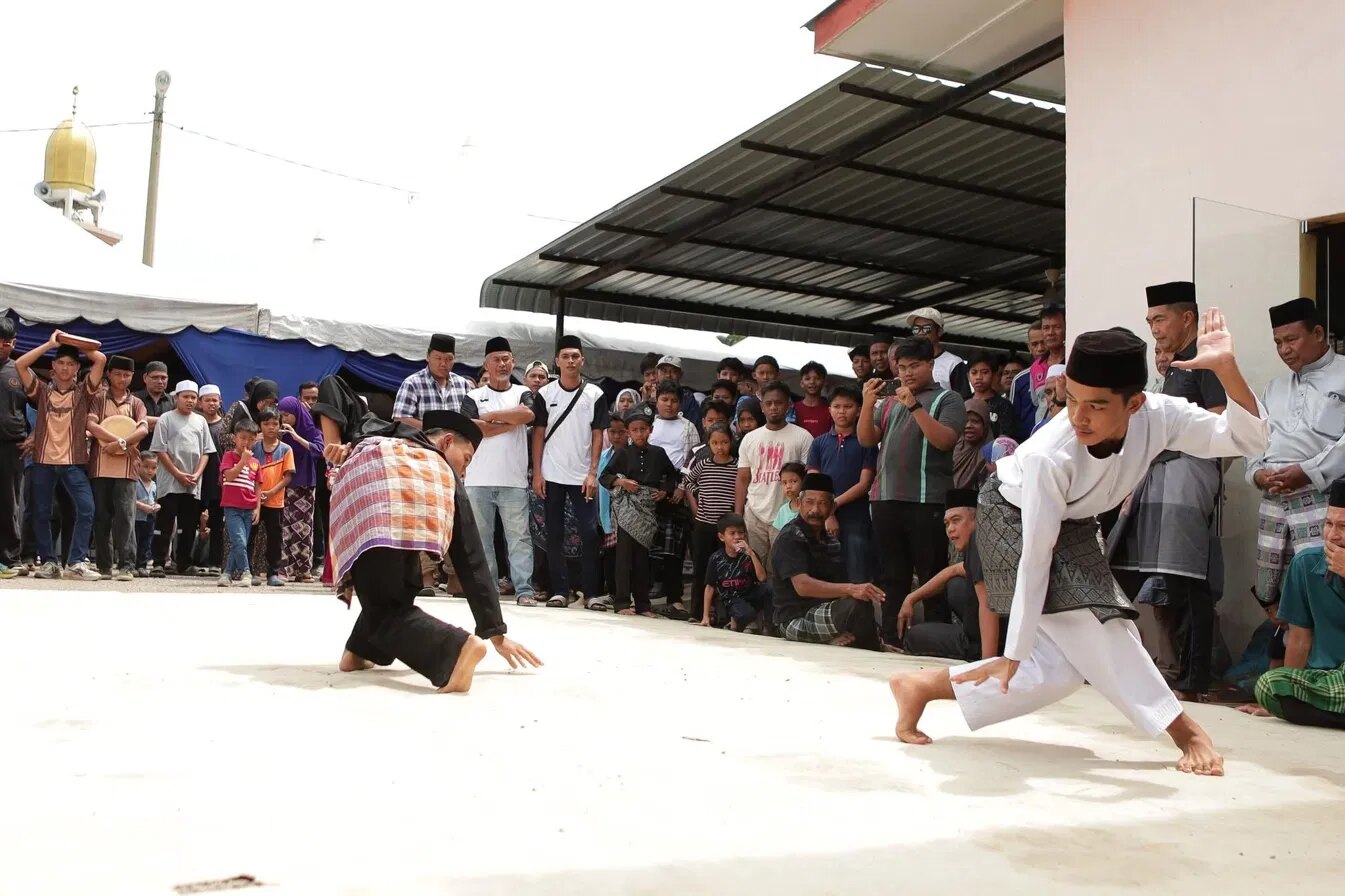 Dua pesilat mempersembahkan buah Seni Silat Sendeng Asli Pahang di hadapan orang kampung.