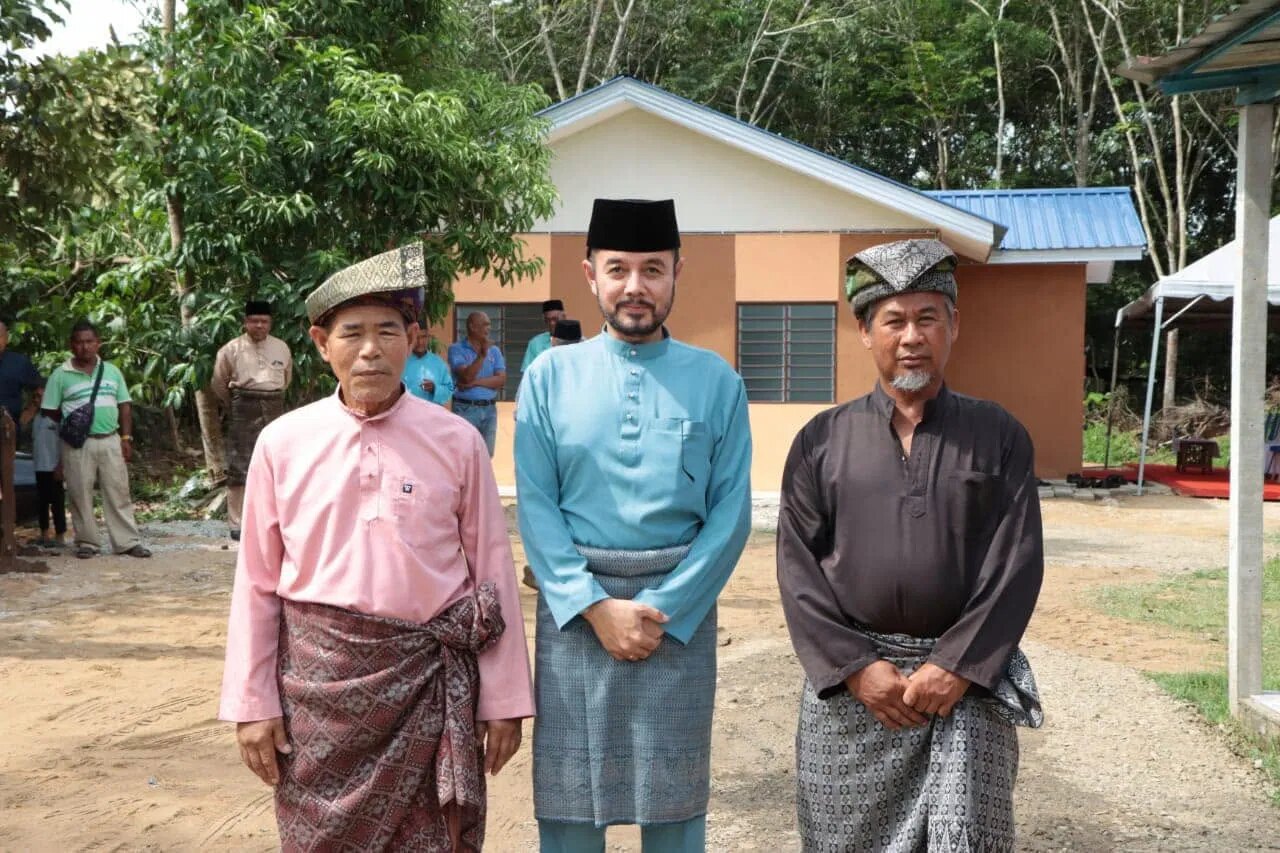 Tiga tokoh berpakaian Melayu lengkap di hadapan bangunan laman.